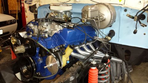 1978 Ford Bronco - A close-up view of a rebuilt Ford V8 engine, painted blue with chrome accents, installed in a vehicle's engine bay. The engine features new…