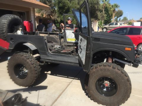 1987 Suzuki Samurai - This heavily modified off-road vehicle features a prominent roll cage and oversized tires.