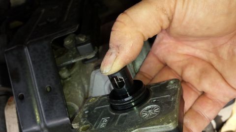 1991 Buick Reatta - A hand is shown installing or removing a mass air flow sensor from a vehicle's engine bay.