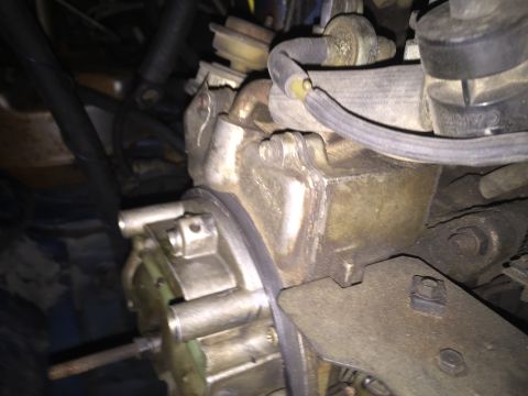 1984 Ford Bronco - Engine part detail, likely a carburetor, with visible hoses and mounting hardware.