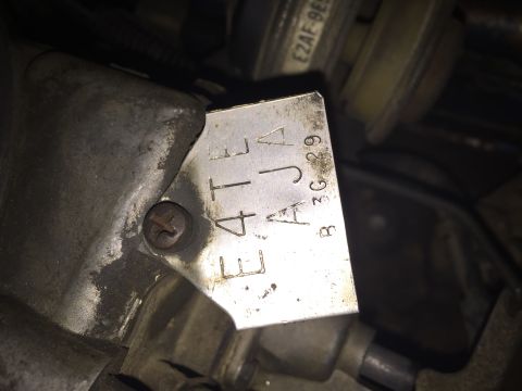 1984 Ford Bronco - Close-up of an engine component a stamped metal identification tag with alphanumeric characters.