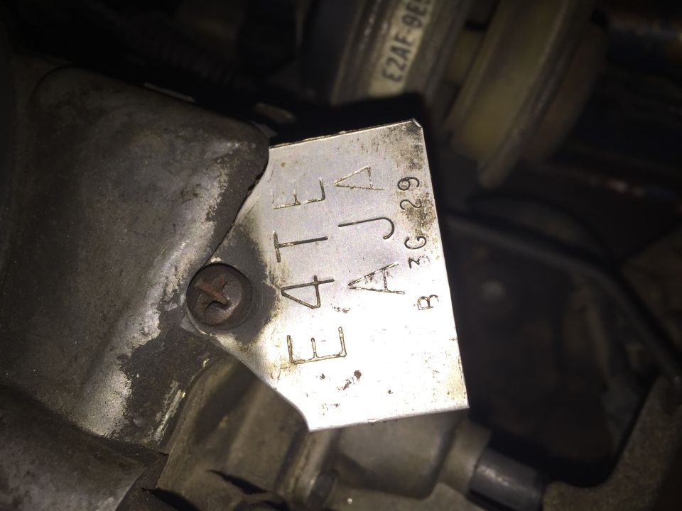 Engine part with stamped metal tag showing E4TJ A B3G 29
