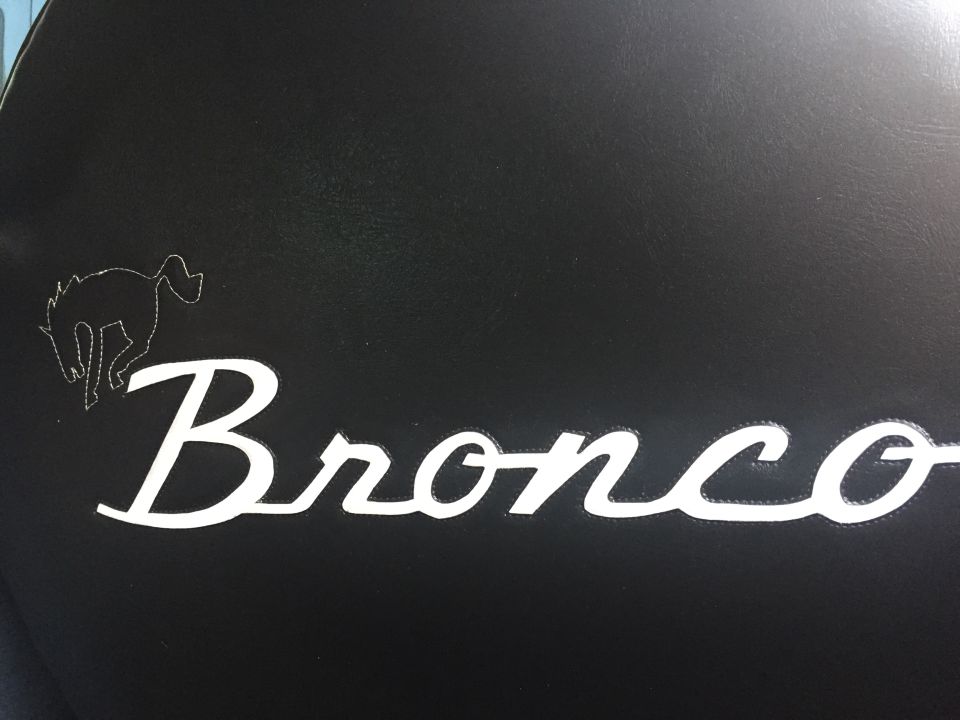 Bronco script with running horse logo on black background. Supermotors.net watermark