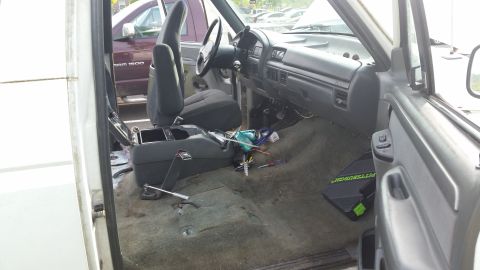1993 Ford Bronco - The interior of a white SUV, possibly a 1992 model, is shown with tools scattered on the floor and console.
