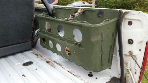 1993 Ford Bronco - A green cargo carrier is secured in the bed of a pickup truck, with a person visible in the background.