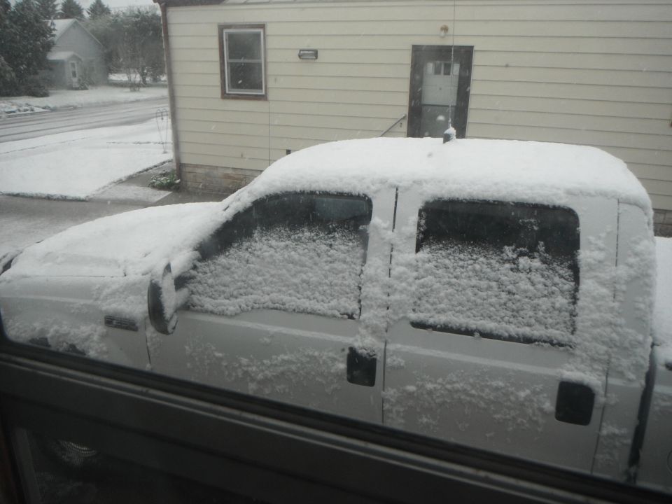 White 2000 Ford F-250 pickup truck with snow on its body and windows, seen from the side