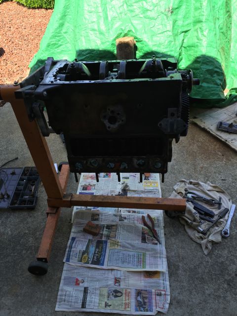1946 Jeep Willys - An engine block sits on a stand, surrounded by tools and newspapers, ready for work.