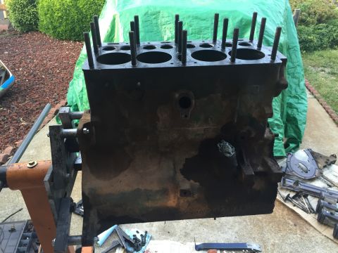 1946 Jeep Willys - An engine block is shown mounted on an engine stand, with parts and tools scattered around it.