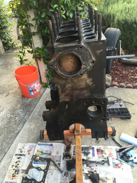 1946 Jeep Willys - Engine block on a stand, with parts laid out on newspapers.