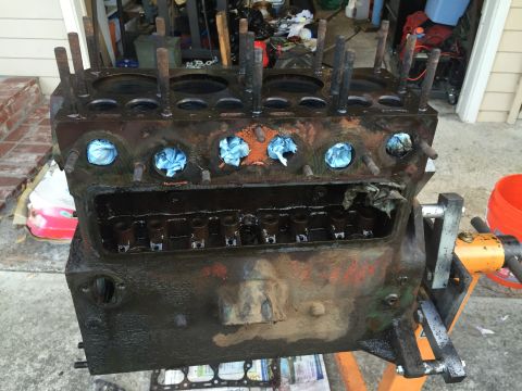 1946 Jeep Willys - This engine block is on a stand, ready for work. Blue rags are stuffed into the cylinder openings.