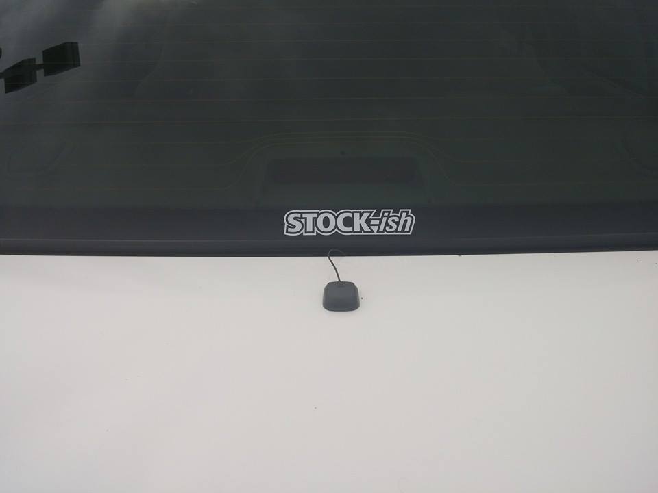 Rear window with "STOCK-ish" sticker and a small black antenna base