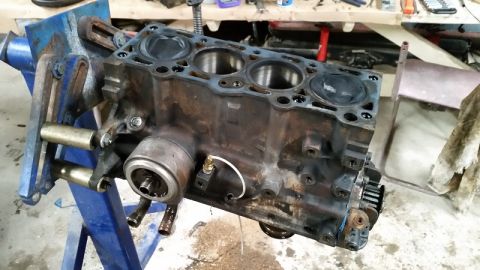 1985 Ford Escort - Engine block, likely from a Ford Escort, is secured in a blue vise for repair or inspection.