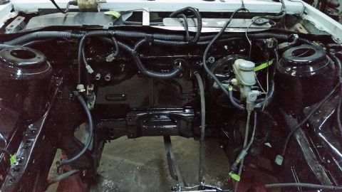 1985 Ford Escort - Car's engine bay during restoration, with wiring and brake components visible.