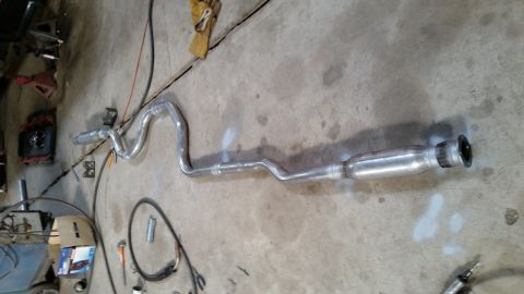 1985 Ford Escort - Exhaust system pipe on concrete floor, possibly for a car or truck.