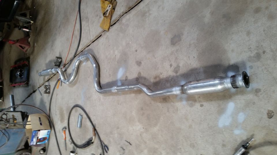 Exhaust system pipe laid out on concrete floor