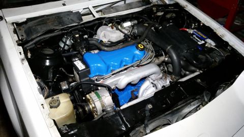 1985 Ford Escort - Close-up view of a car's engine bay, showing various components and wiring.
