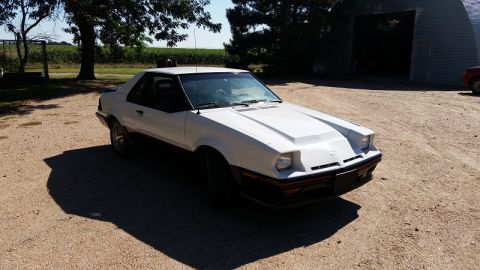 1985 Ford Escort - This 1985 Ford EXP Turbo coupe has a distinctive hood scoop and is parked outdoors.