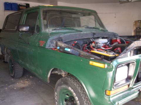 1979 Ford Bronco - This green 1979 Ford Bronco is shown from a 3/4 front angle with its hood open, revealing the engine compartment.