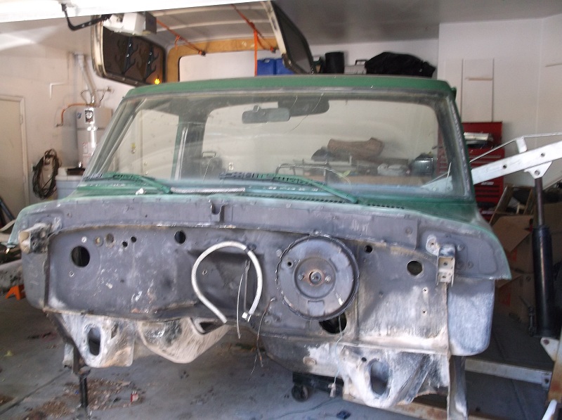 Green 1979 Ford Bronco front clip, disassembled in a garage