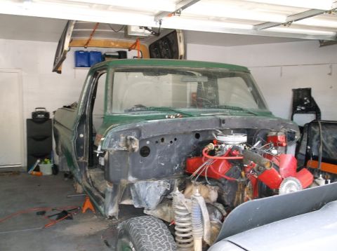1979 Ford Bronco - This 1979 Ford Bronco is undergoing repairs in a garage, with its front end and engine exposed.