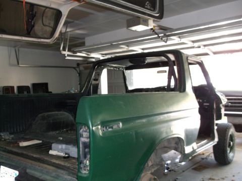 1979 Ford Bronco - This green Ford Bronco is in a garage, appearing to be under repair or restoration with its doors removed.