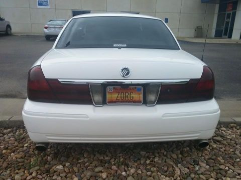 2000 Mercury Grand Marquis - Rear view of a white 2000 Mercury Grand Marquis sedan parked on gravel.