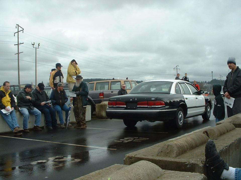 Rear view of a black and white 1999 Ford Crown Victoria police car at an auction