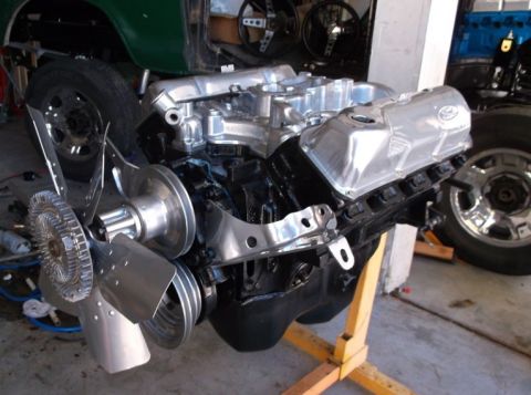 1979 Ford Bronco - A V8 engine with polished aluminum valve covers and a large fan is displayed on an engine stand.
