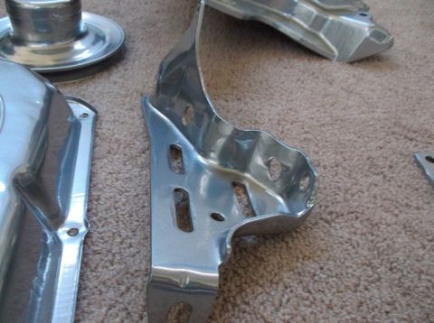 1979 Ford Bronco - Several chrome-plated metal brackets are laid out on a carpeted surface, with a SuperMotors.net watermark visible.