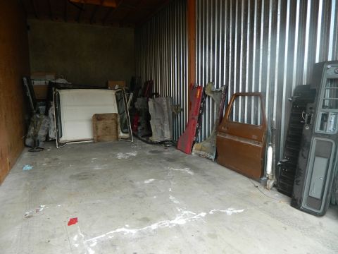 1979 Ford Bronco - A collection of vehicle parts are stored inside a metal storage unit, with a "SUPERMOTORS.NET" watermark visible.