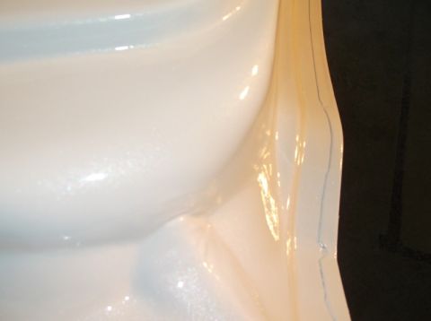 1979 Ford Bronco - A close-up view of a white plastic component, possibly a mold or interior trim piece.