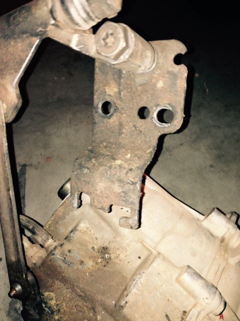 1995 Ford Bronco - Rusty bracket attached to a transfer case housing, likely a vehicle part.