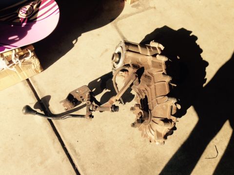 1995 Ford Bronco - A dusty transfer case and its shifter are laid out on a concrete surface, with a skateboard visible nearby.