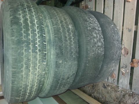 1989 Ford Ranger - A set of four tires are stacked and appear to be for sale, with no visible vehicle information.