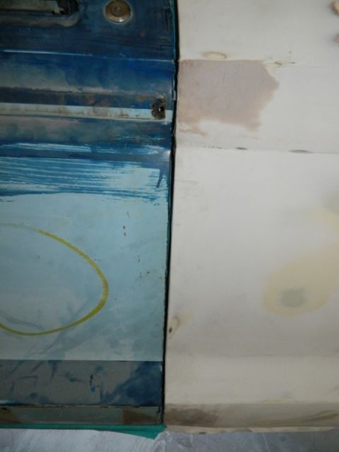 1979 Ford Bronco - Close-up of a vehicle door seam, showing blue paint and white body filler.