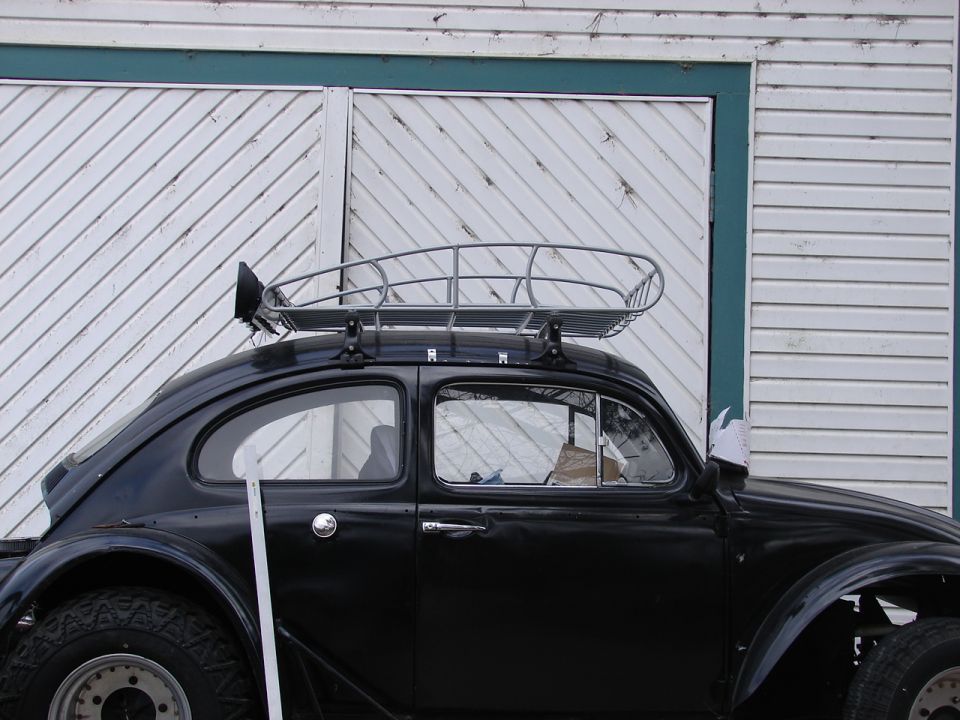 Black 1964 Volkswagen Beetle with a roof rack and off-road tires