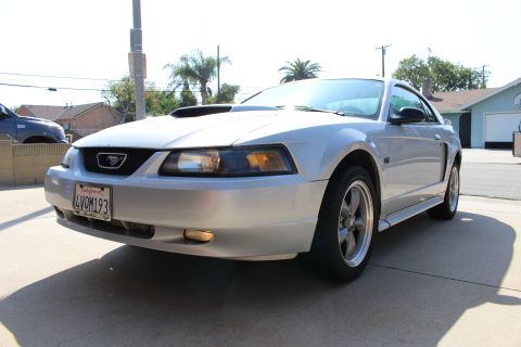 2002 Ford Mustang - This silver 2002 Ford Mustang is shown from the front 3/4 angle, parked on a driveway.