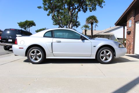 2002 Ford Mustang - Side profile of a silver 2002 Ford Mustang GT parked on a driveway.