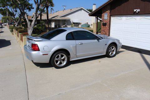 2002 Ford Mustang - Silver 2002 Ford Mustang parked in a driveway next to a garage.
