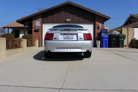 2002 Ford Mustang - Silver 2002 Ford Mustang GT parked in front of a brick house and garage.