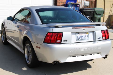 2002 Ford Mustang - Rear view of a silver 2002 Ford Mustang GT parked in front of a garage.
