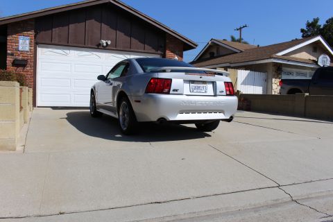 2002 Ford Mustang - Rear view of a silver 2002 Ford Mustang GT parked in a residential driveway.