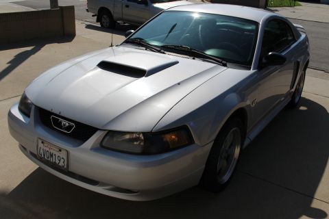 2002 Ford Mustang - Front 3/4 view of a silver 2002 Ford Mustang coupe showing the hood scoop and grille.