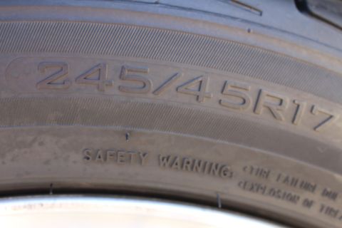 2002 Ford Mustang - Close-up of a tire sidewall displaying the size 245/45R17 and a safety warning.
