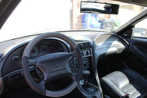 2002 Ford Mustang - Interior view of a 2002 Ford Mustang, showing the steering wheel, dashboard, and center console.