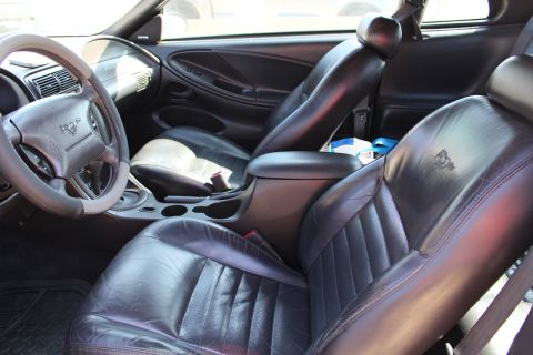 2002 Ford Mustang - Interior view of a 2002 Ford Mustang, black leather seats and dashboard details.