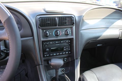 2002 Ford Mustang - The interior of a 2002 Ford Mustang displays its dashboard, center console, and steering wheel.