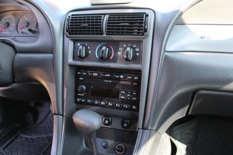 2002 Ford Mustang - Interior view of a 2002 Ford Mustang, showing the center console with radio, climate controls, and gear shifter.