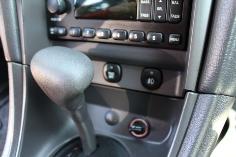 2002 Ford Mustang - Interior view of a 2002 Ford Mustang, focusing on the center console with gear shifter and radio.