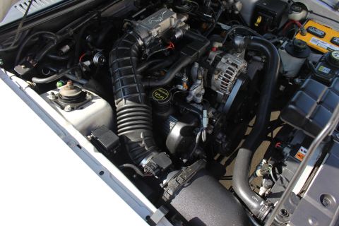 2002 Ford Mustang - The engine bay of a 2002 Ford Mustang is visible, with the V8 engine and associated components clearly displayed.